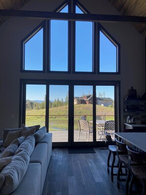 Una habitación amplia con un gran ventanal corredera que da a un patio exterior.
