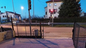 A paved walkway with a metal gate, a traffic light, and a building in the background. - Beautiful renovated house (Mirano)