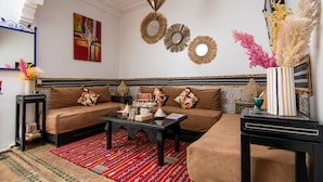 A living room with a sofa set, a coffee table, decorative mirrors, and a patterned rug. - Riad Karim (Marrakech)
