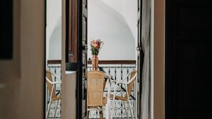 A view through an open door to a balcony with wicker chairs and a vase of flowers. - Riad Karim (Marrakech)