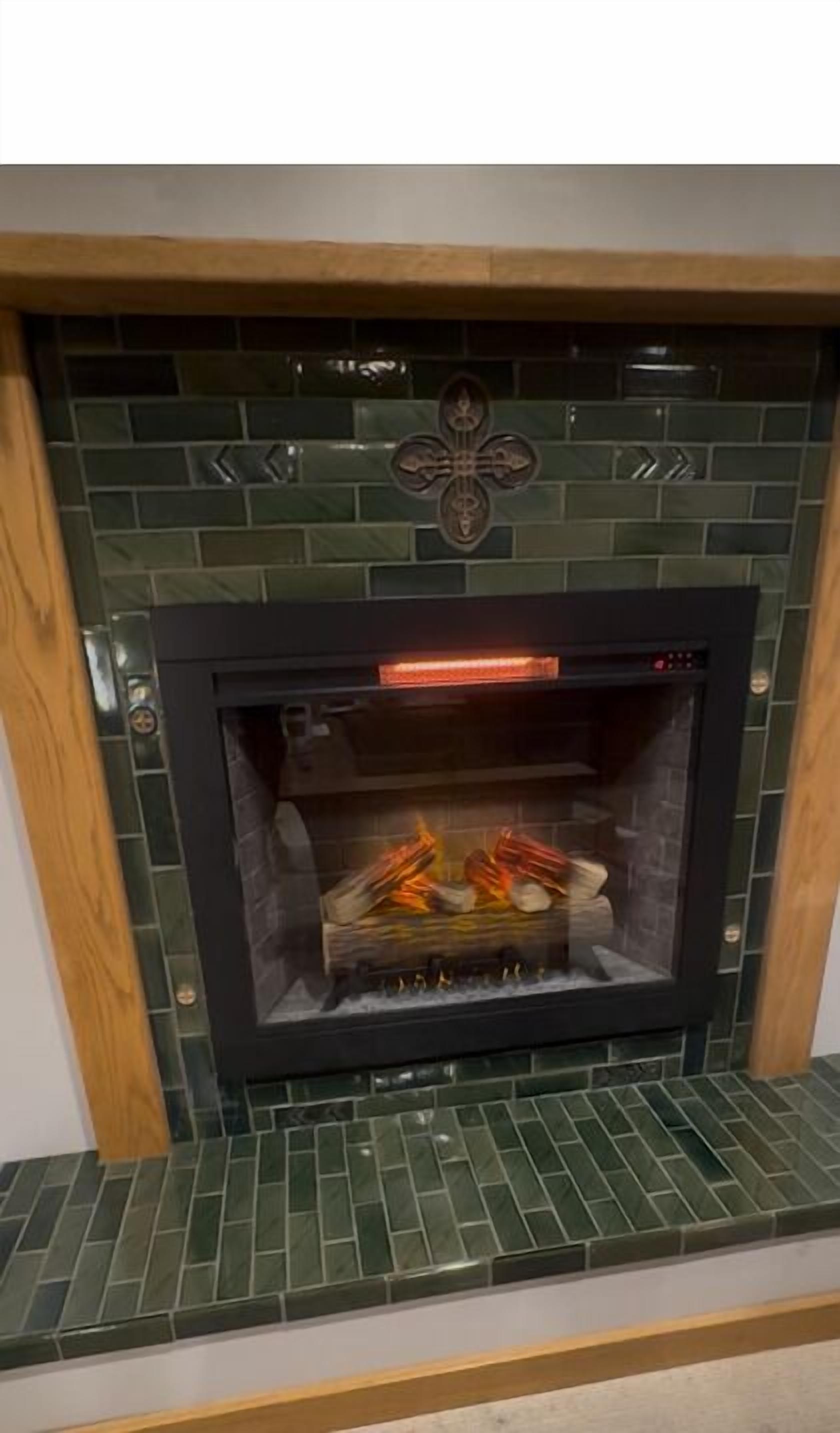 Une cheminée avec un manteau orné de carreaux et un motif décoratif au-dessus.