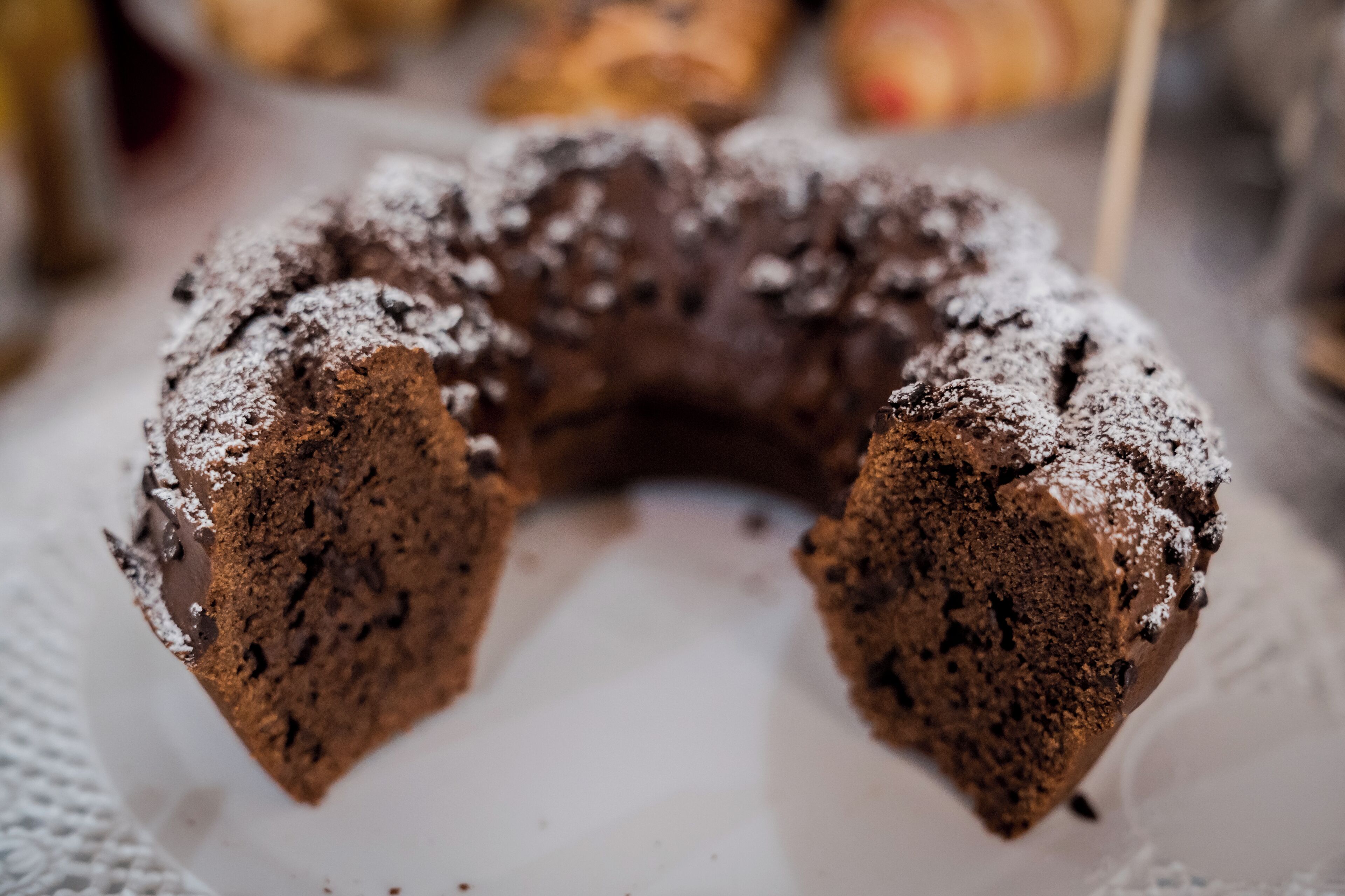 Ein Bundtkuchen mit Puderzucker auf einem weißen Teller.