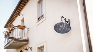 Un edificio con un cartel que dice "Bed & LaZita" y un balcón con plantas en macetas.