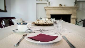 A dining table set with a plate, napkin, fork, and cup.