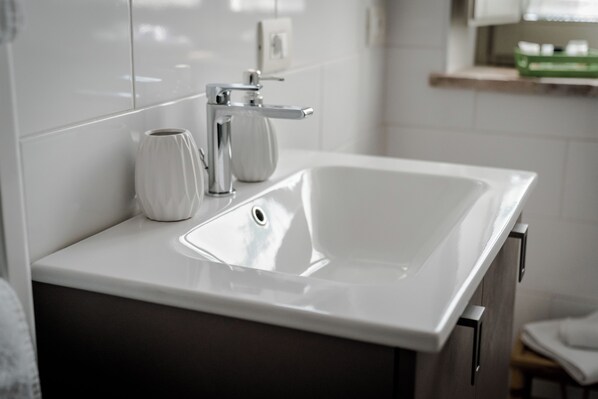 A modern bathroom with a white sink, a vase, and a mirror. - LaZita B&B (Montecastrilli)
