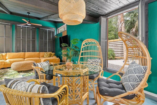 Relax in this stylish room with a vibrant accent wall, comfortable sofa, and large window offering a view of the outdoors.