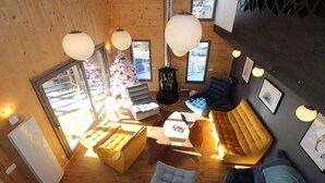 A cozy interior with wooden walls, a large window, and a seating area with sofas and a table. - Chalet Archi, the mountain par excellence (Font-Romeu-Odeillo-Via)