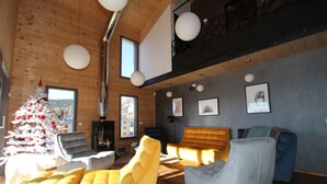 A modern living room with a wooden ceiling, a Christmas tree, and a fireplace. - Chalet Archi, the mountain par excellence (Font-Romeu-Odeillo-Via)