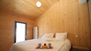 A wooden-paneled bedroom with a bed, pillows, and a breakfast tray with croissants and cups. - Chalet Archi, the mountain par excellence (Font-Romeu-Odeillo-Via)