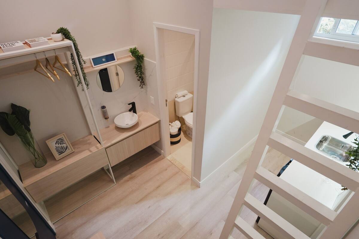 Ein modernes Badezimmer mit einem Holzkosmetikschrank, einer Toilette und einer Duschkabine.