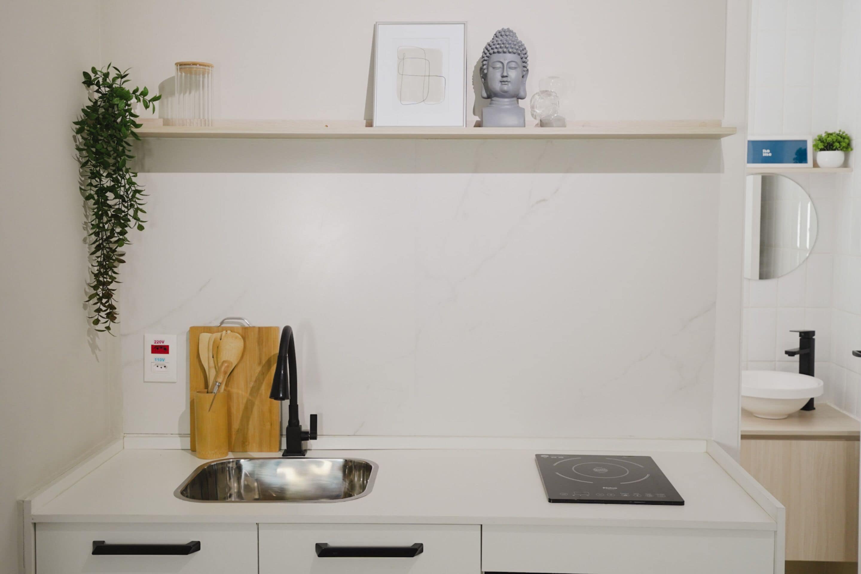 Una cucina moderna con lavello integrato, un piano cottura e un tagliere di legno.