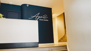 A reception area with a black wall and a white reception desk. - Apê Metrô Paraíso (São Paulo)