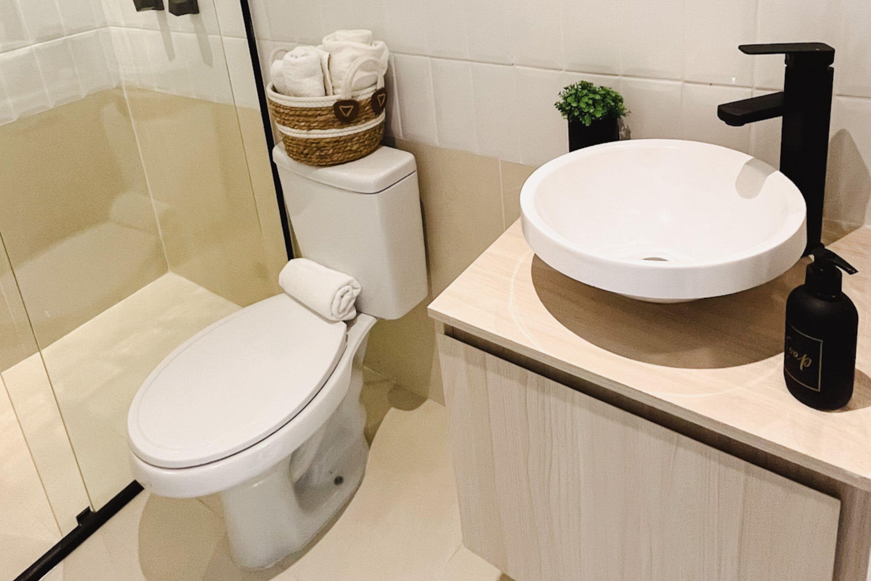 A modern bathroom with a toilet, a sink, and a shower.