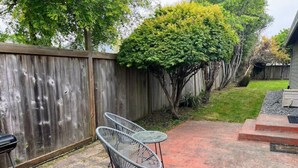 Une terrasse avec deux chaises en métal et une petite table ronde.