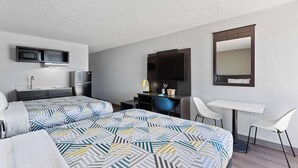 A hotel room with two beds, a desk, a chair, a mirror, a TV, and a microwave. - Studio 6 Pecos, Tx (Pecos)