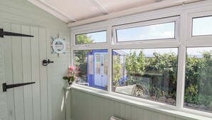 Une pièce donnant sur un jardin, avec une porte bleue et un radiateur blanc.