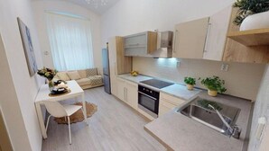 Une cuisine compacte comprenant un coin repas, un four encastré et un évier.