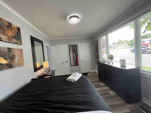 Ein Schlafzimmer mit einem Bett, einem Schminktisch, einem Spiegel und Bildern an den Wänden.