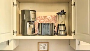 Une cuisine équipée d’une machine à café, d’un grille-pain et d’un mixeur.