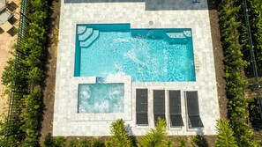 Ein Dachpool mit Whirlpool, umgeben von einer gefliesten Terrasse und Grünpflanzen.