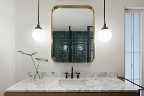 A bathroom with a marble countertop, a gold-framed mirror, and two pendant lights. - Kimpton Virgilio Polanco by IHG (Mexico City)