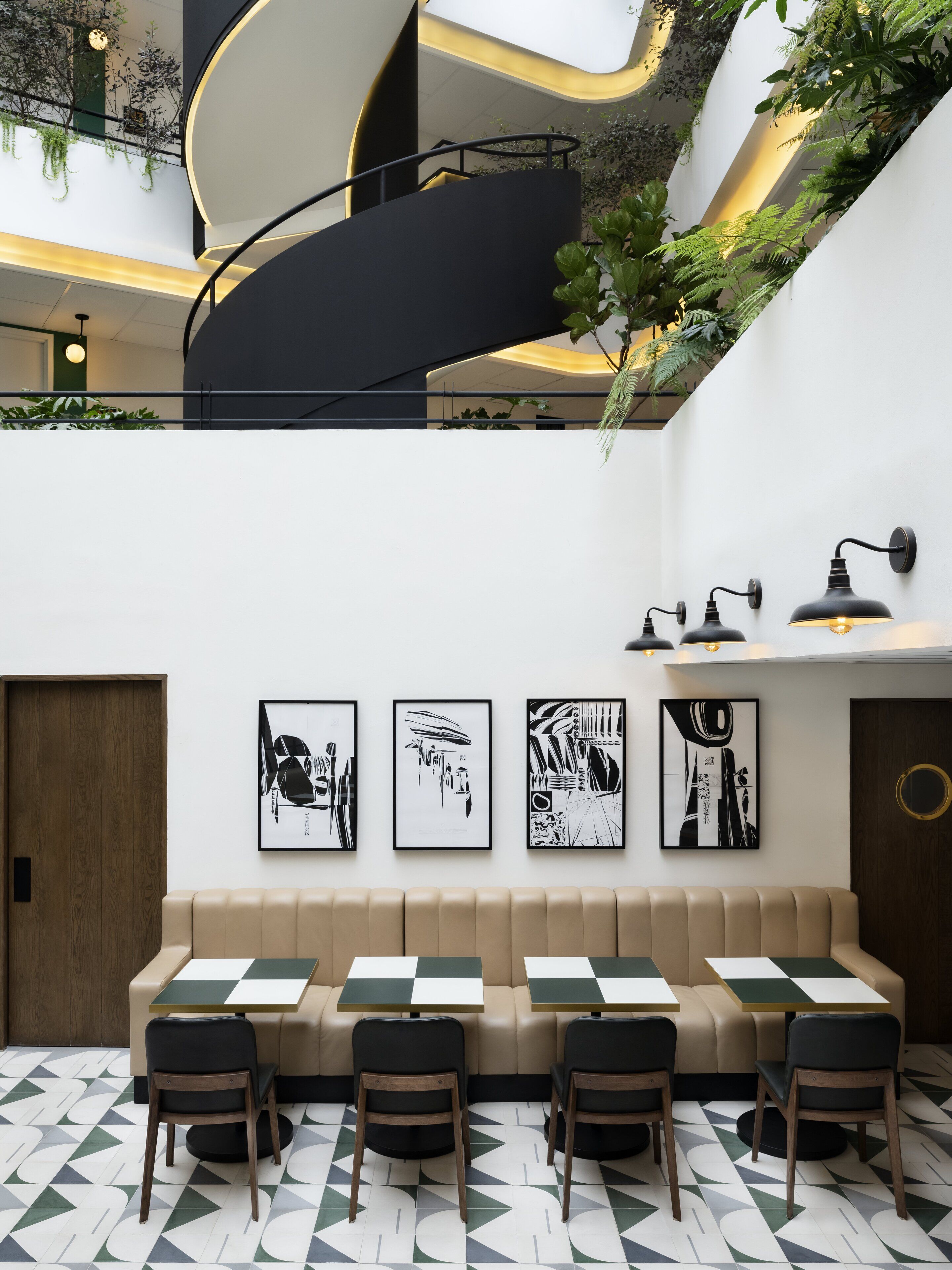 A modern interior with a seating area, a staircase, and wall-mounted artwork.