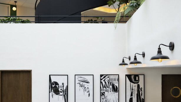 A modern interior with a seating area, a staircase, and wall-mounted artwork.