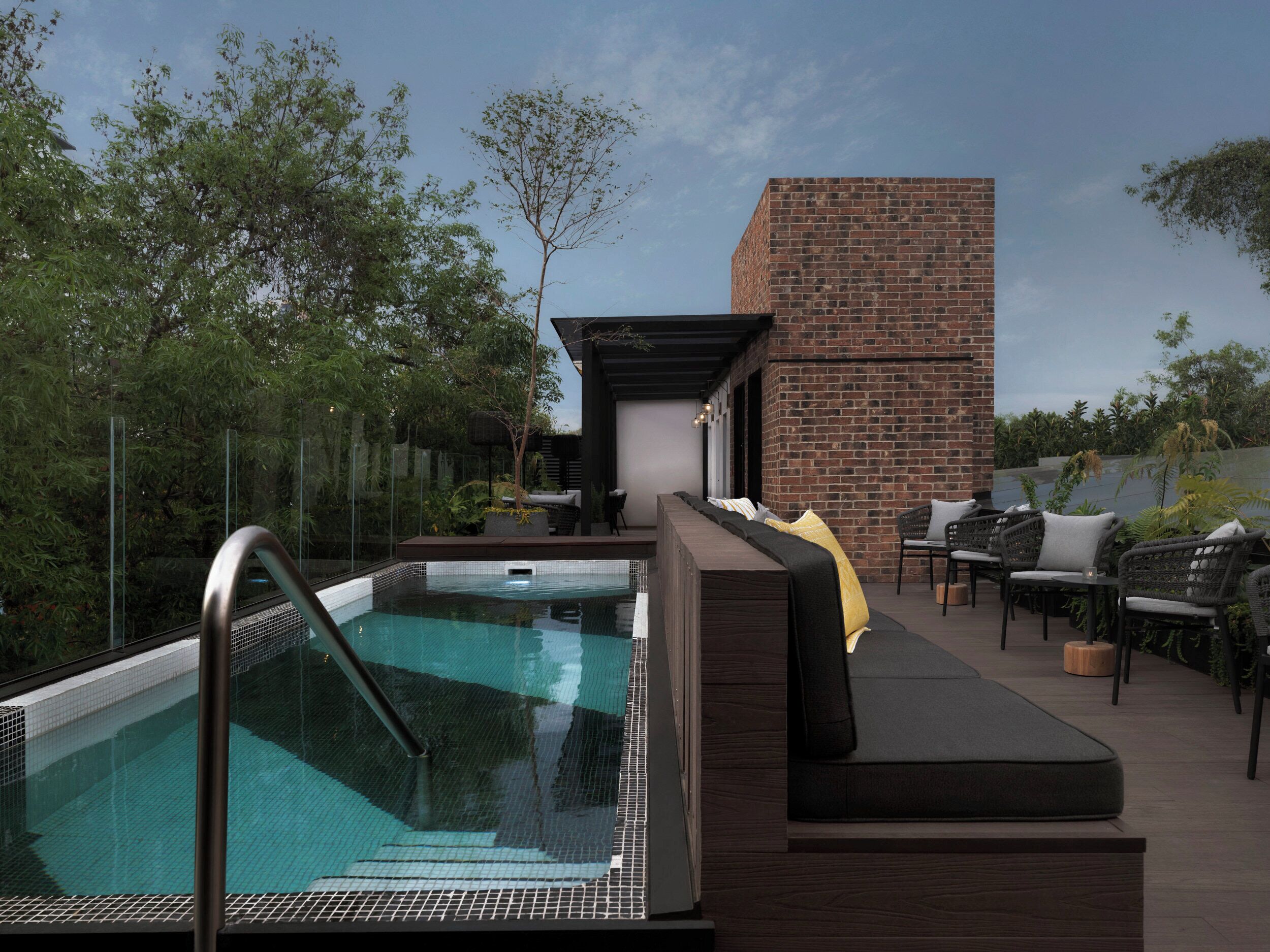 Área de piscina no terraço com espaço para assentos e parede de tijolos.