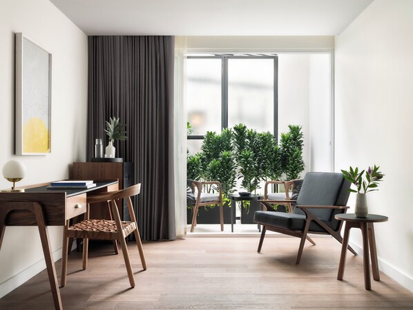 A modern living room with a wooden desk, two chairs, a small table, and a potted plant. - Kimpton Virgilio Polanco by IHG (Mexico City)