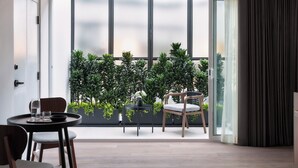 A modern living room with a dining area, large windows, and a view of a balcony with plants. - Kimpton Virgilio Polanco by IHG (Mexico City)