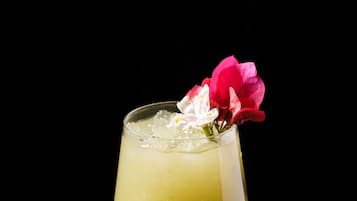 A cocktail in a stemmed glass with a flower garnish.