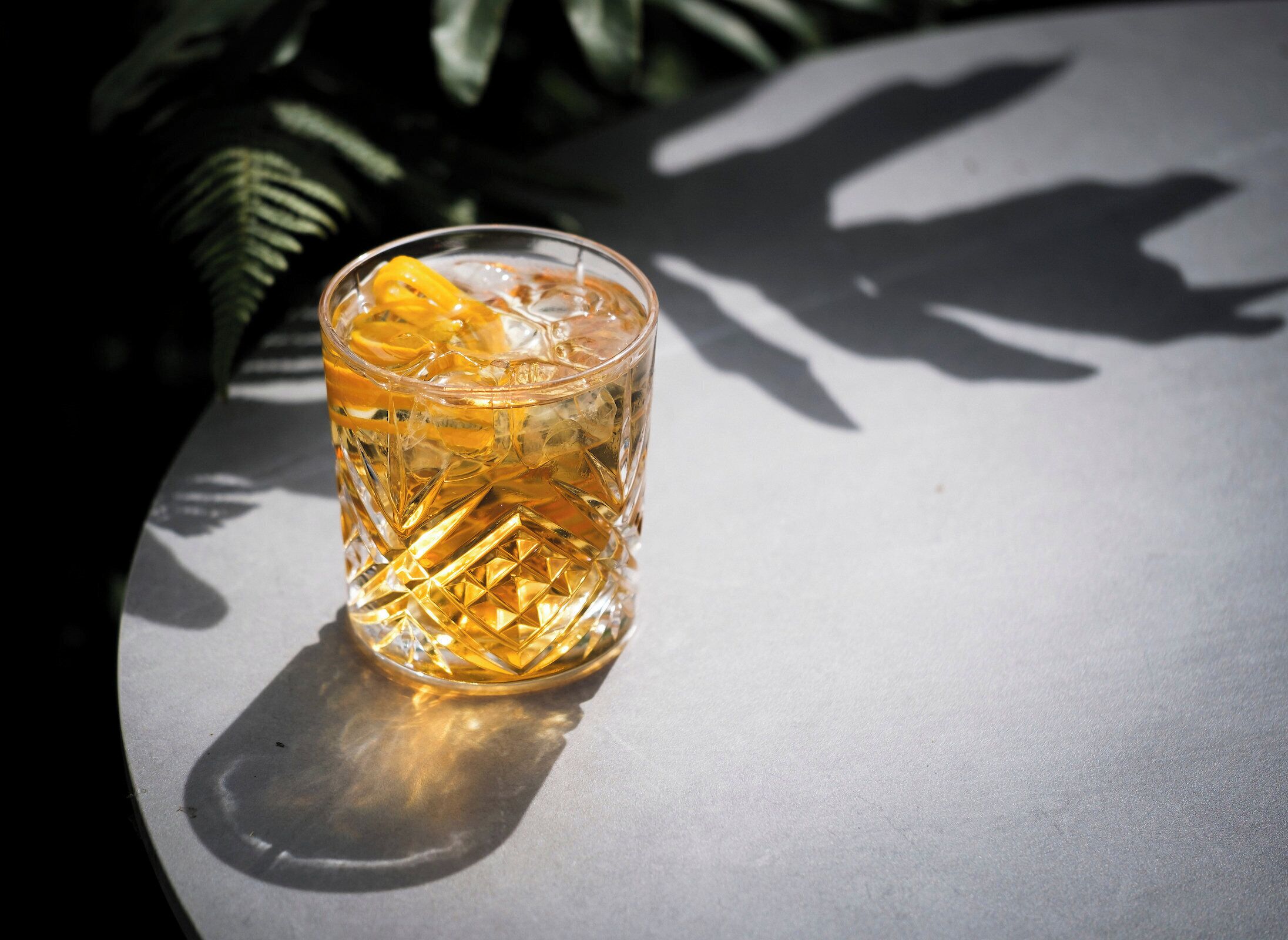 A glass with a textured pattern and a lemon slice on a table.