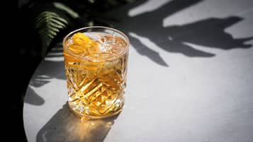A glass with a textured pattern and a lemon slice on a table.