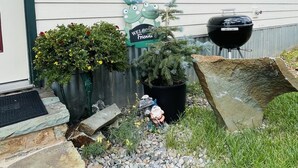 A house with a welcoming sign, a welcome mat, a stone pathway, and a barbecue grill. - The Shotgun House. (Silverton)