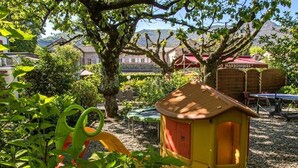 Un parque infantil con un tobogán y una casita amarilla.