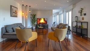 Una sala de estar moderna con chimenea, dos sofás y una mesita de centro.