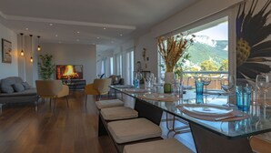 Un comedor moderno con una mesa de vidrio, sillas y vistas al exterior.