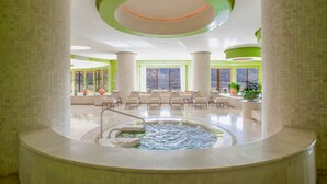 A spa area with a hot tub, seating, and large windows.