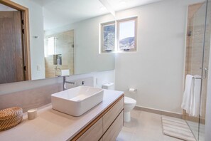 A modern bathroom with a large mirror, a vessel sink, a toilet, and a shower area. - 1604 4BR/5BA Oceanfront PH Loreto @ Danzante Bay (Ensenada Blanca)