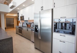 Una cocina moderna con electrodomésticos de acero inoxidable, armarios de madera y un horno empotrado.