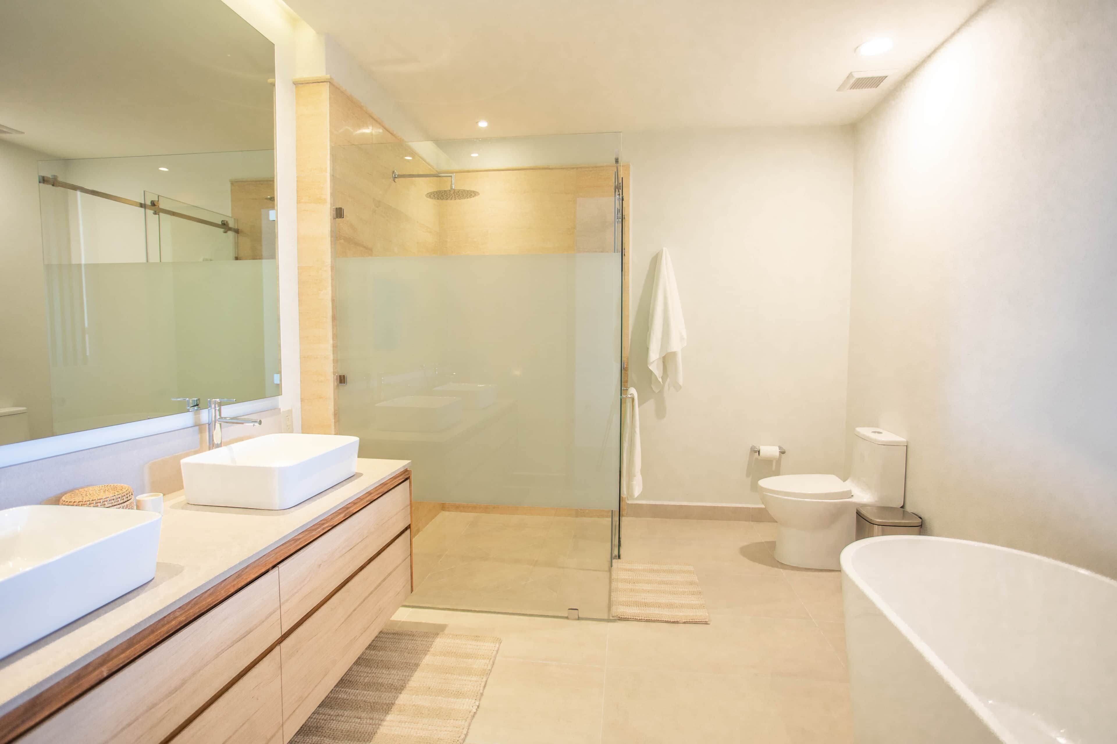 Ein modernes Badezimmer mit Duschkabine aus Glas, einer weißen Badewanne und einem großen Spiegel.