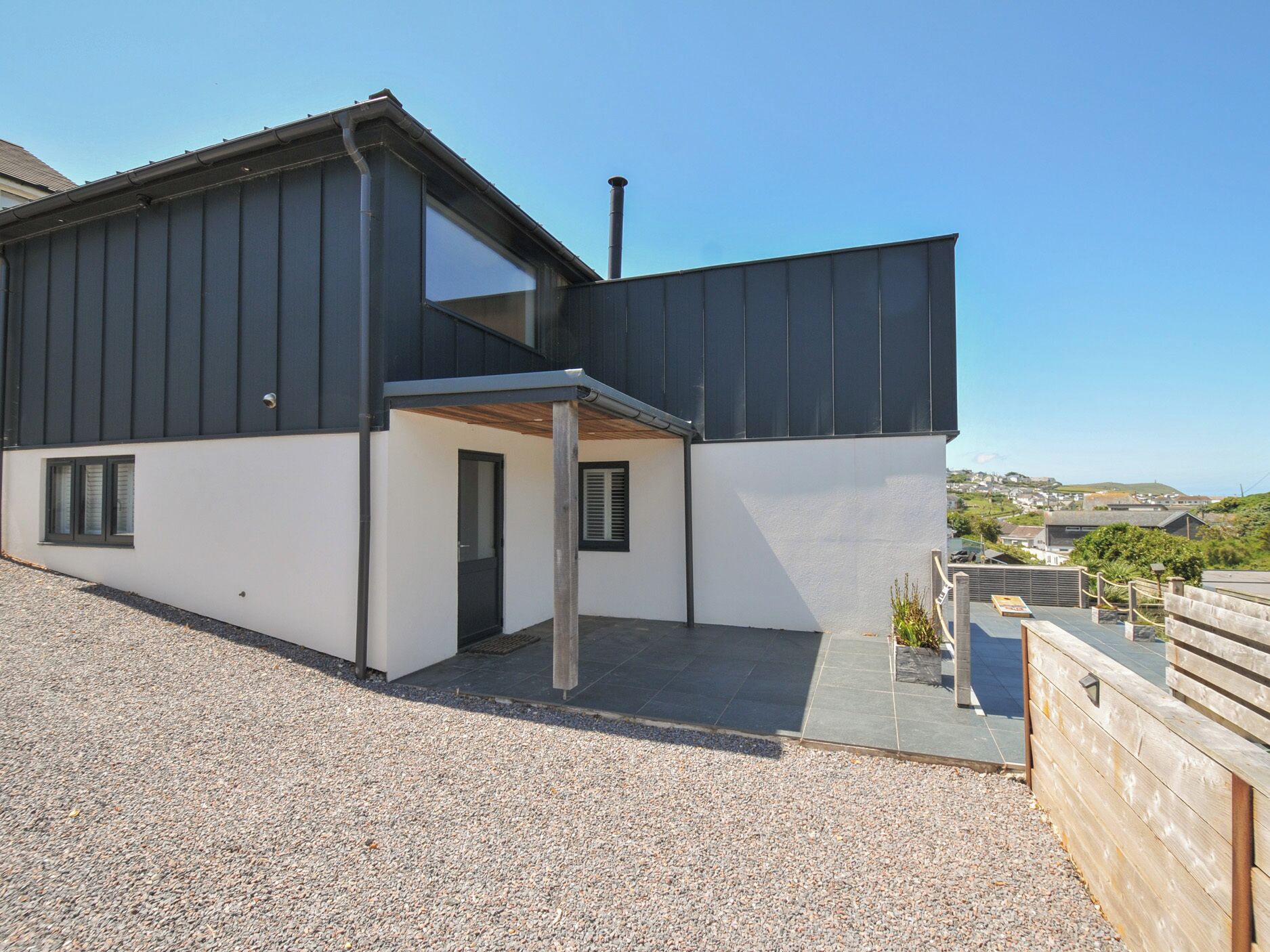 Un bâtiment moderne à deux étages, doté d’un toit plat, d’une entrée couverte et d’une allée gravillonnée.