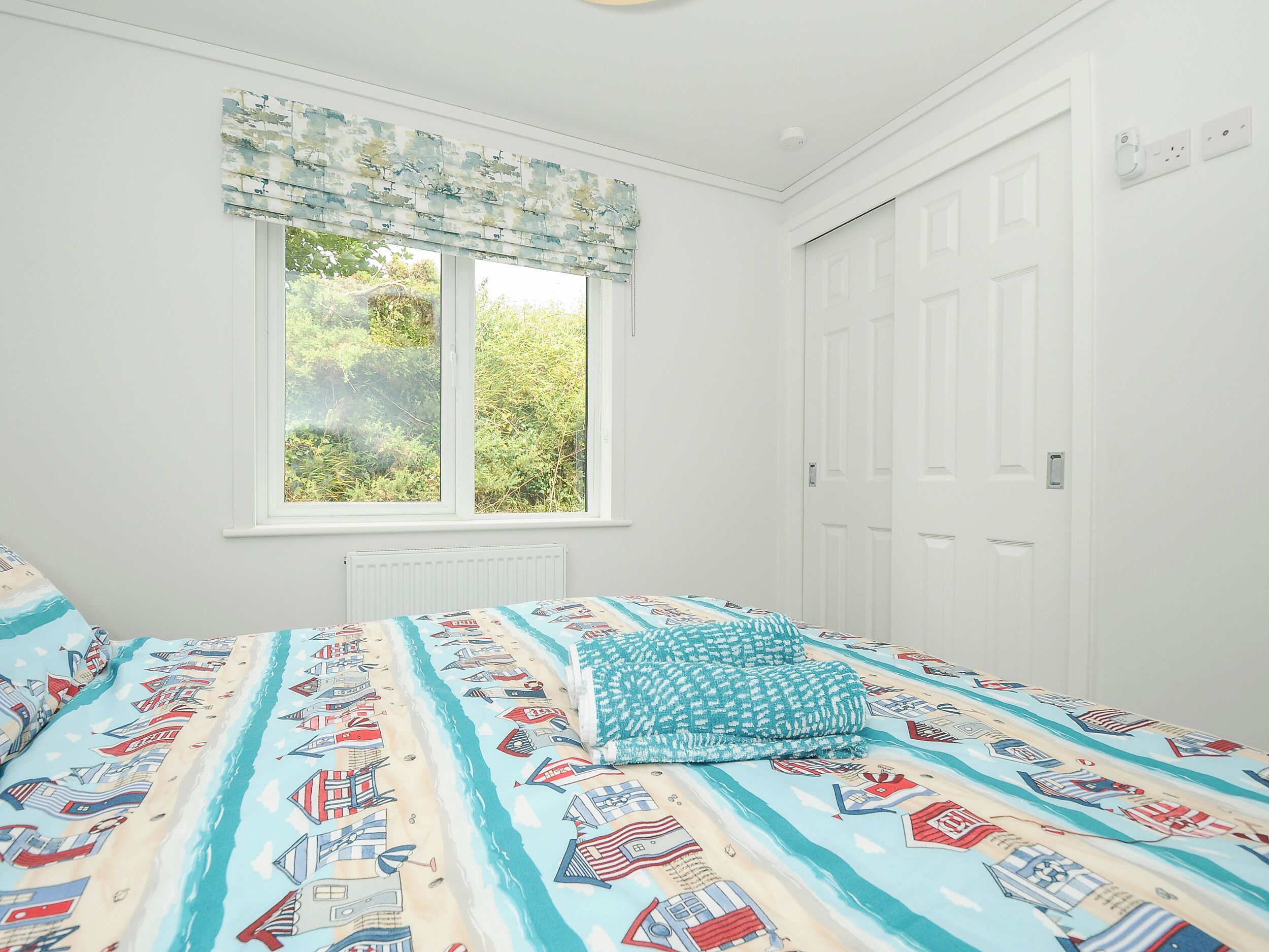 Ein Schlafzimmer mit Bett, Fenster und Tür.