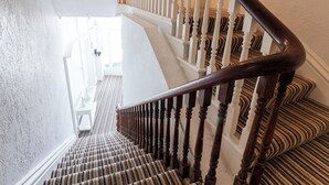 A staircase with wooden balusters and a striped carpet. - 6 Beach View @ Beaconsfield House (Bridlington)