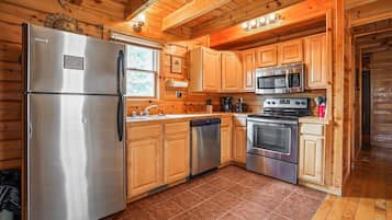 Une cuisine avec des meubles en bois, des appareils électroménagers en acier inoxydable et un sol carrelé.