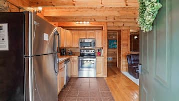 A compact kitchen with a refrigerator, microwave, and oven.
