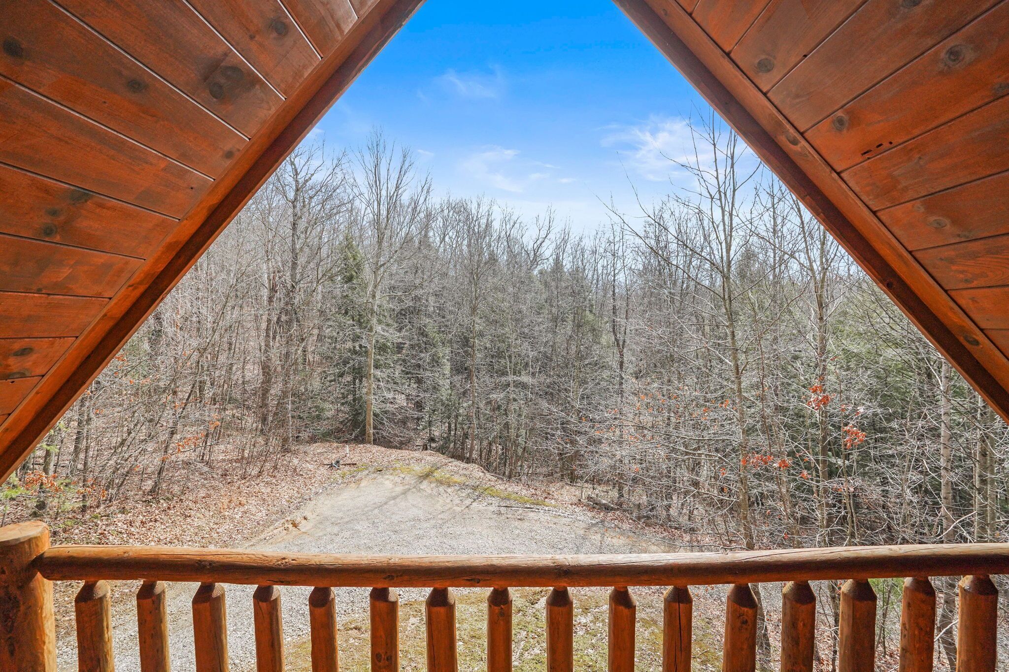 Une terrasse en bois offrant une vue sur une zone boisée.