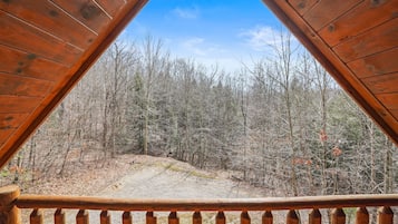 Une terrasse en bois offrant une vue sur une zone boisée.