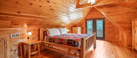 Une chambre dans une cabane en bois, avec un lit, un bureau et une chaise.