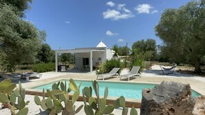A pool area with a white gazebo, lounge chairs, and cacti. - Trullo Oscar (Ceglie Messapica)